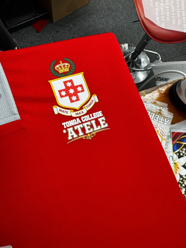 Tonga College ʻAtele crest printed on a red polo